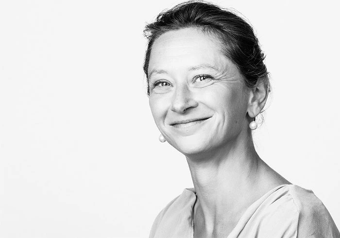 Sie hat dunkle Haare und lacht freundlich in die Kamera.