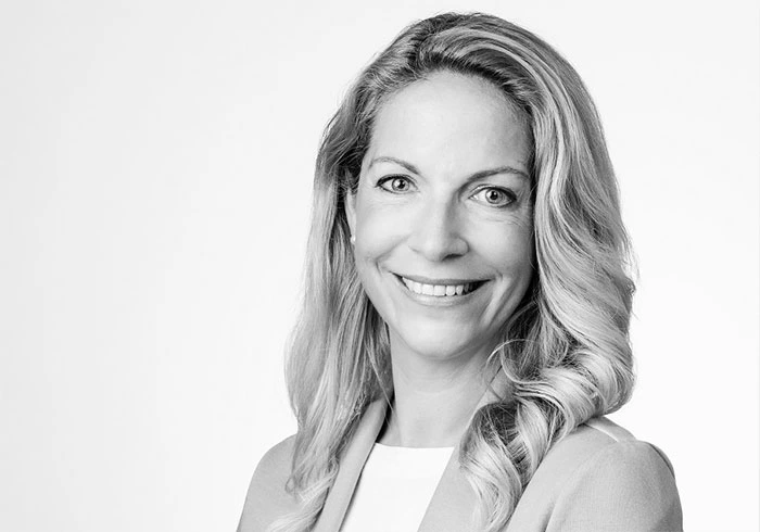 Sie hat langes, blondes Haar und lacht freundlich in die Kamera.