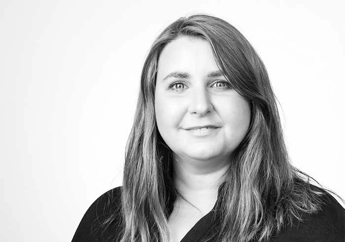 Frau mit langen Haaren und offenem Blick, leichtes Lächeln.