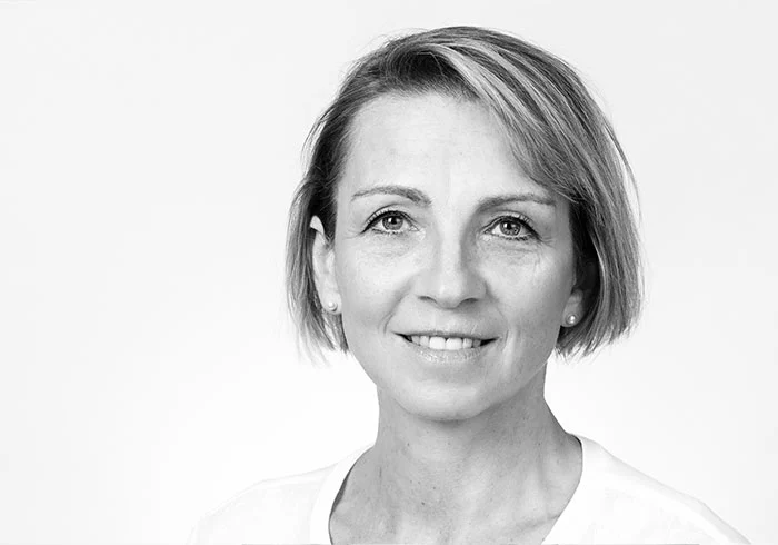Sie hat glatte, kinnlange Haare und lächelt in die Kamera.