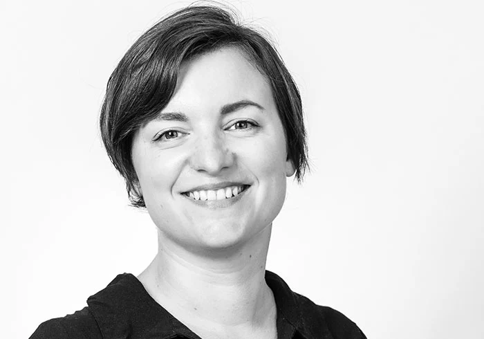 Sie hat mittellange dunkle Haare und lächelt freundlich in die Kamera.